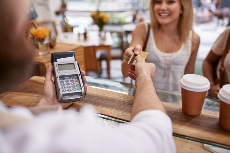 a server receives a payment card from a woman while holding a payment terminal