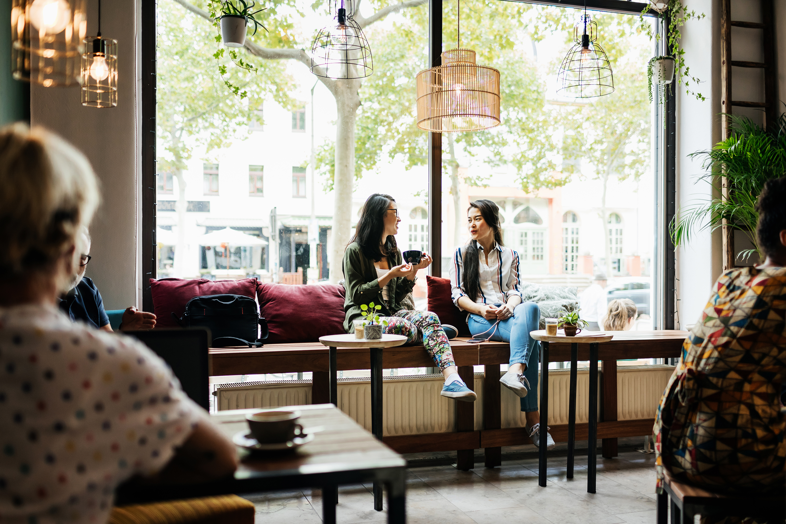 two women sitting in a coffee shop talking