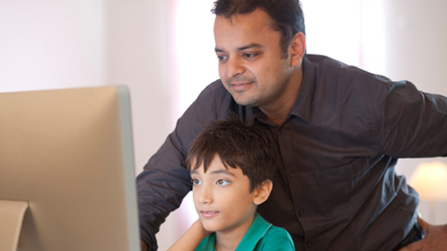 a man and child looking at a computer